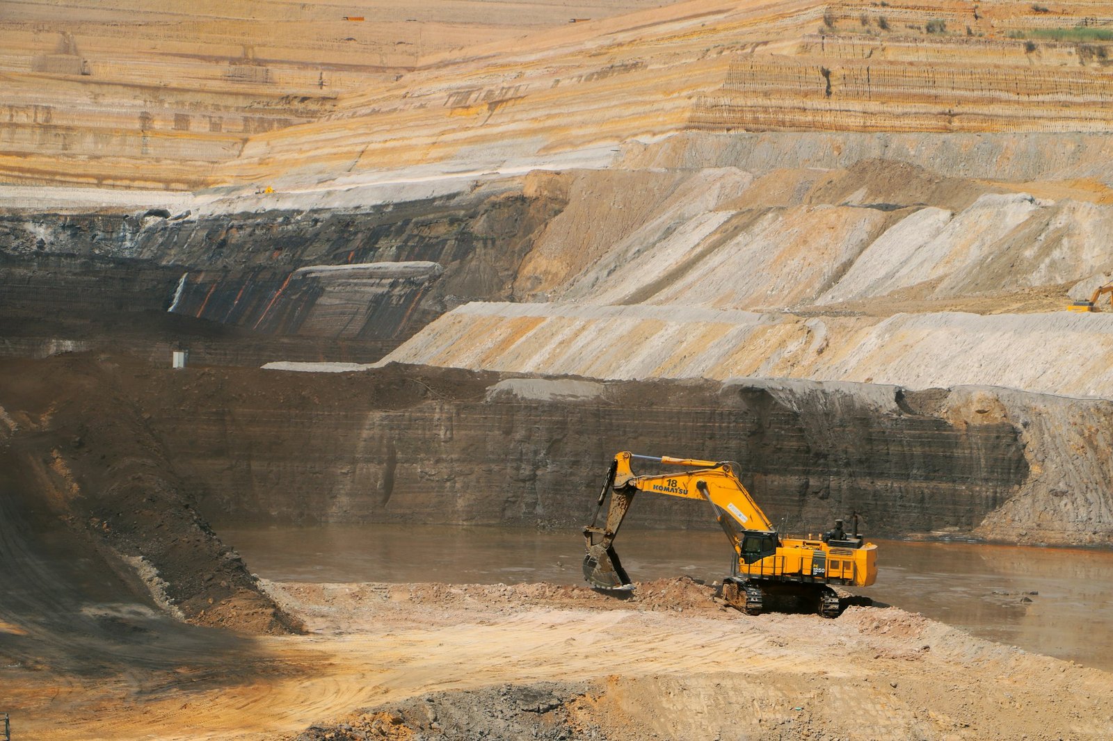Pelle mécanique au travail dans une mine à ciel ouvert aux parois ocre